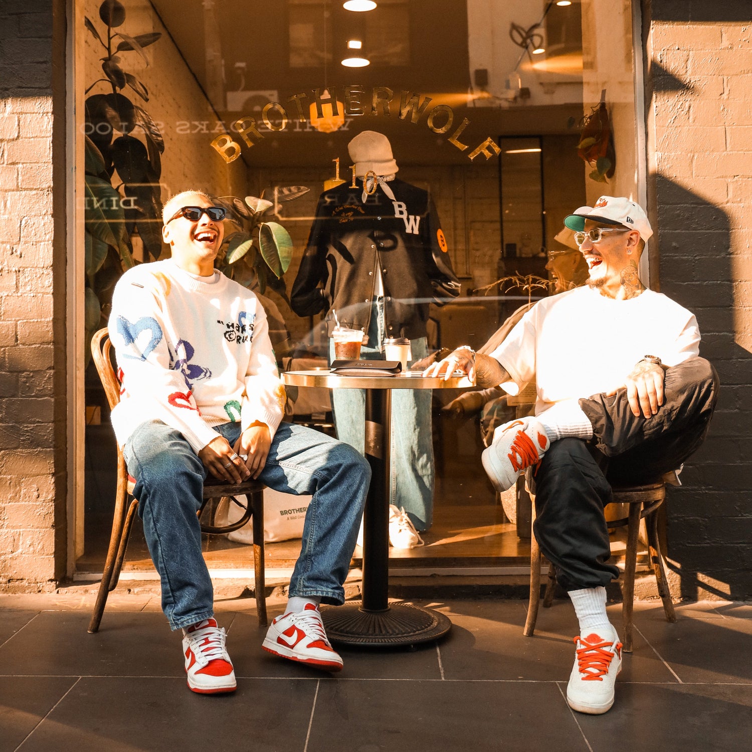 Two male friends wearing A'PAIR sunglasses anf laughing in the streets